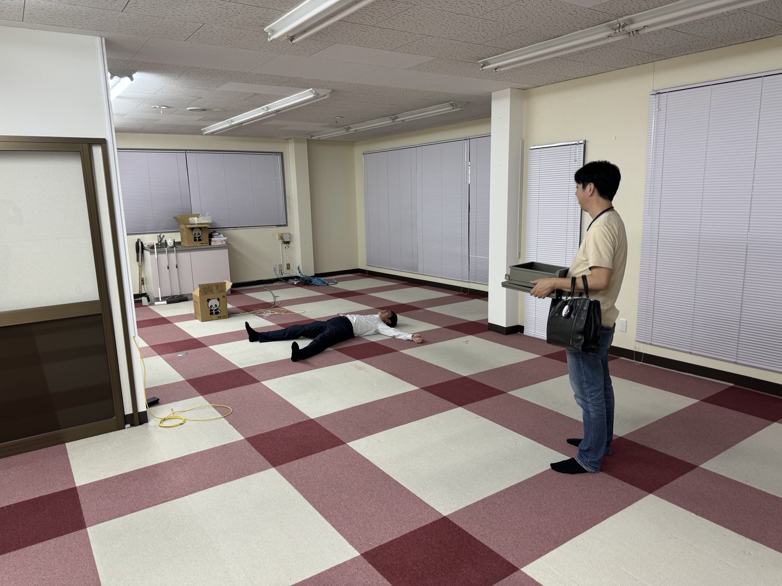 富塚町オフィス最後の日に床へ寝転ぶ袴田所長と見つめる笠原福所長