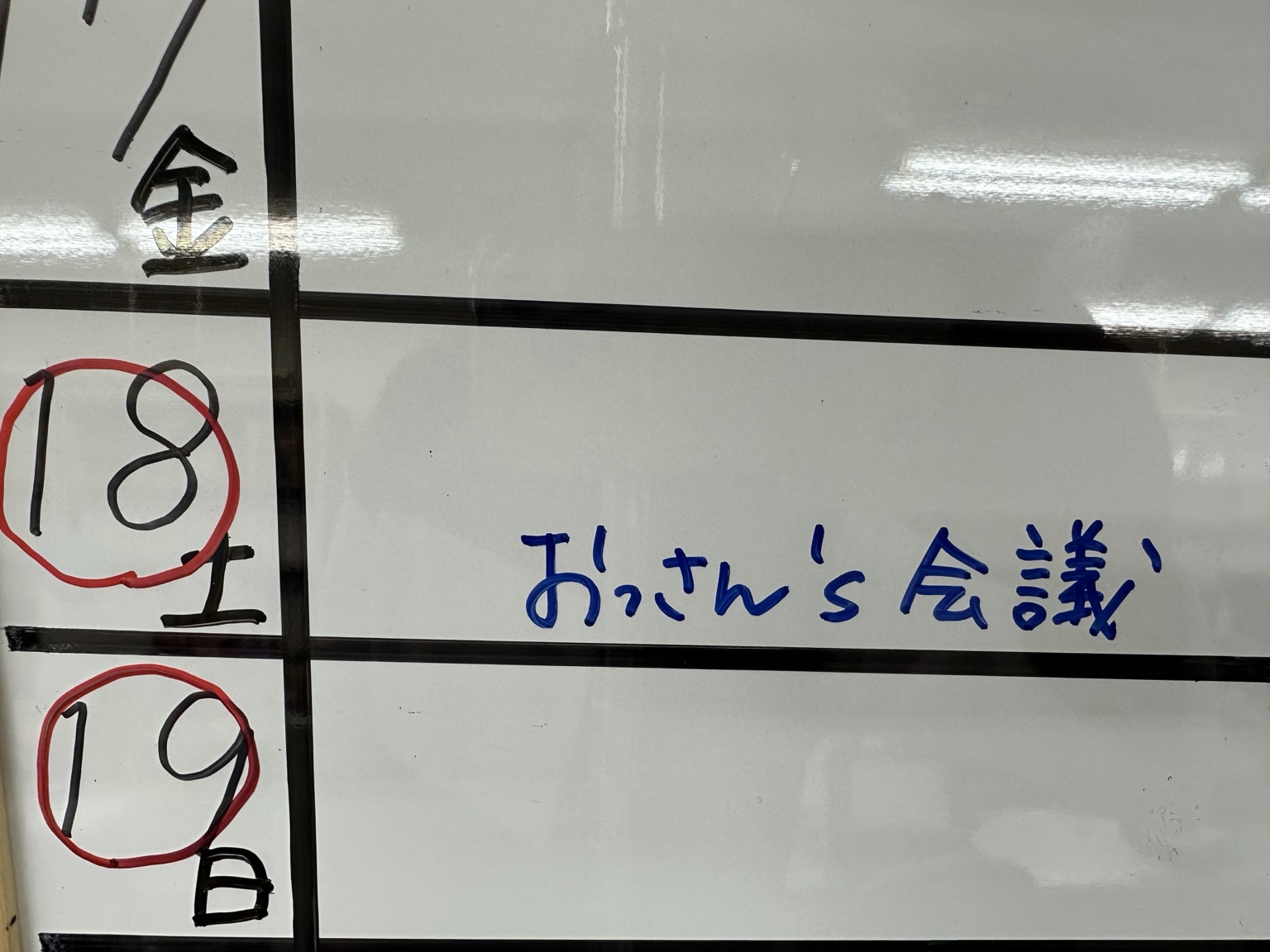 おっさん's会議と書かれた七福神の会議予定ホワイトボード